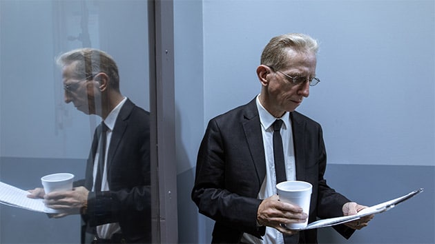 A businessperson wearing a suit and tie is managing a white-collar worker indoors, demonstrating the employment and job opportunities of the business.