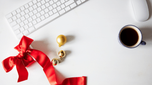 The red bow tie and cup of coffee sit together.