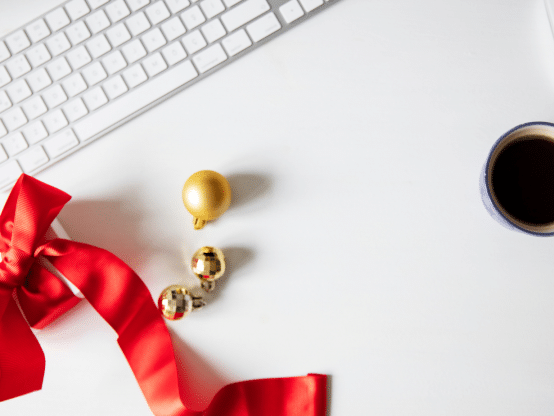 The red bow tie and cup of coffee sit together.