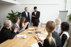 Board room meeting with people sitting around the table.