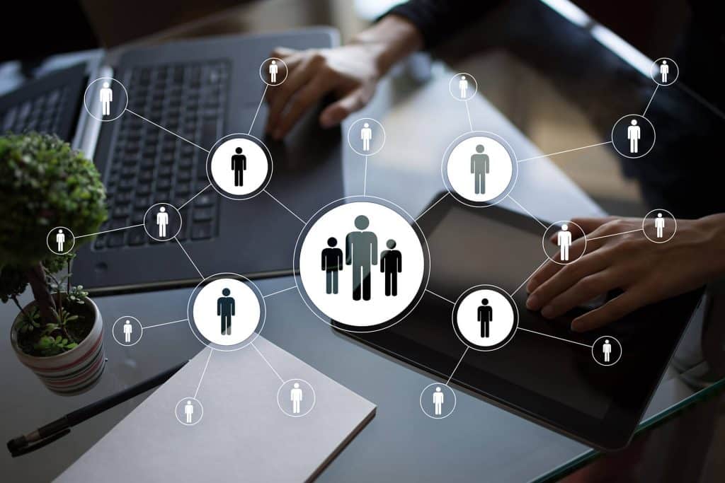 Hands on a laptop keyboard with overlayed graphics representing people being interconnected by technolgoy.