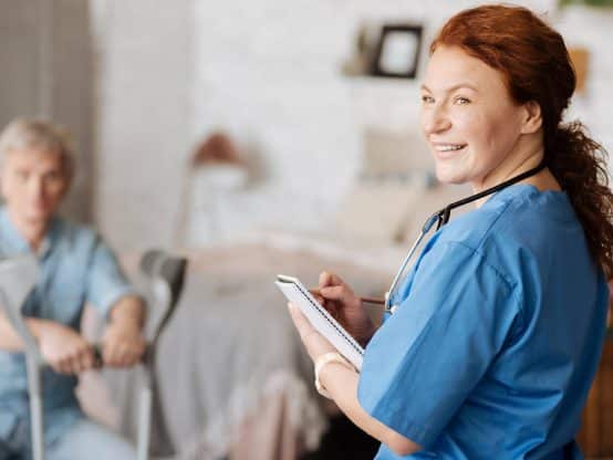 A person with a smiling face is sitting indoors.
