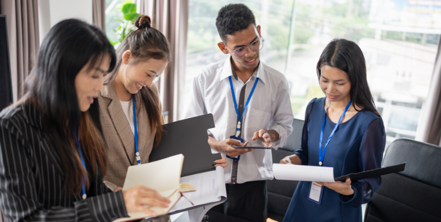 Team of professionals reviewing business documents, representing succession planning for SMEs