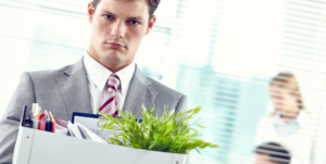 Employee leaving workplace with belongings after redundancy or job loss