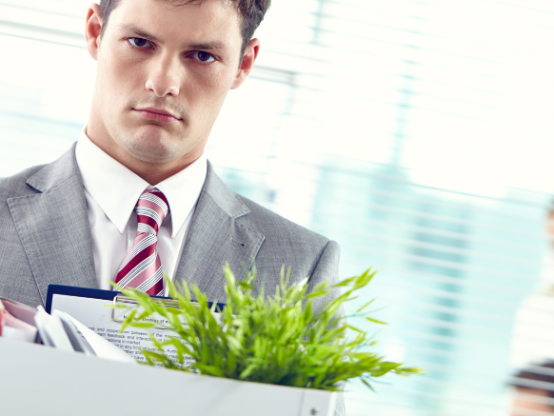 Employee leaving workplace with belongings after redundancy or job loss