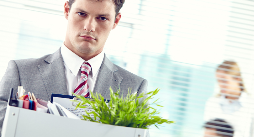 Employee leaving workplace with belongings after redundancy or job loss